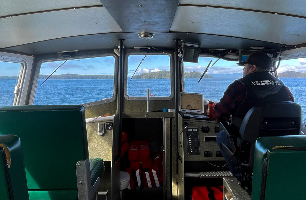 Careers Marine Science View from behind, inside the boat, while a captain drives a boat. Blue ocean is visible through the windshield
